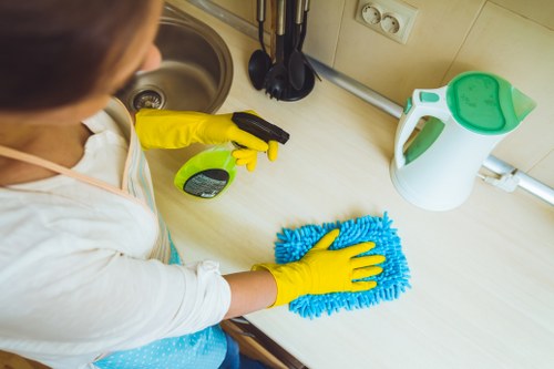 A trained carpet cleaner using protective gloves and footwear